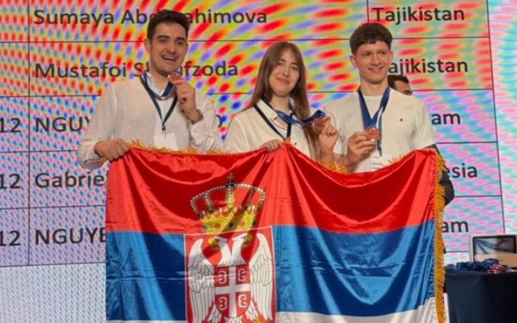 Девять медалей из Сингапура: сербские школьники покорили научную олимпиаду Трое сербских учащихся с медалями держат государственный флаг на церемонии награждения международной научной олимпиады STEMCO в Сингапуре