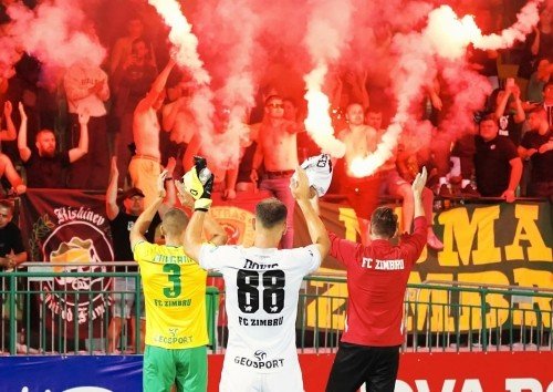 Игроки «Зимбру» приветствуют фанатов на фоне зажжённых файеров после матча молдавской Суперлиги