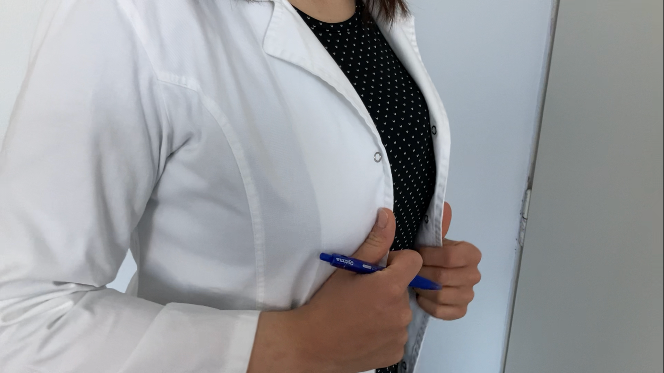 Врач в белом халате с ручкой в руке — крупный план