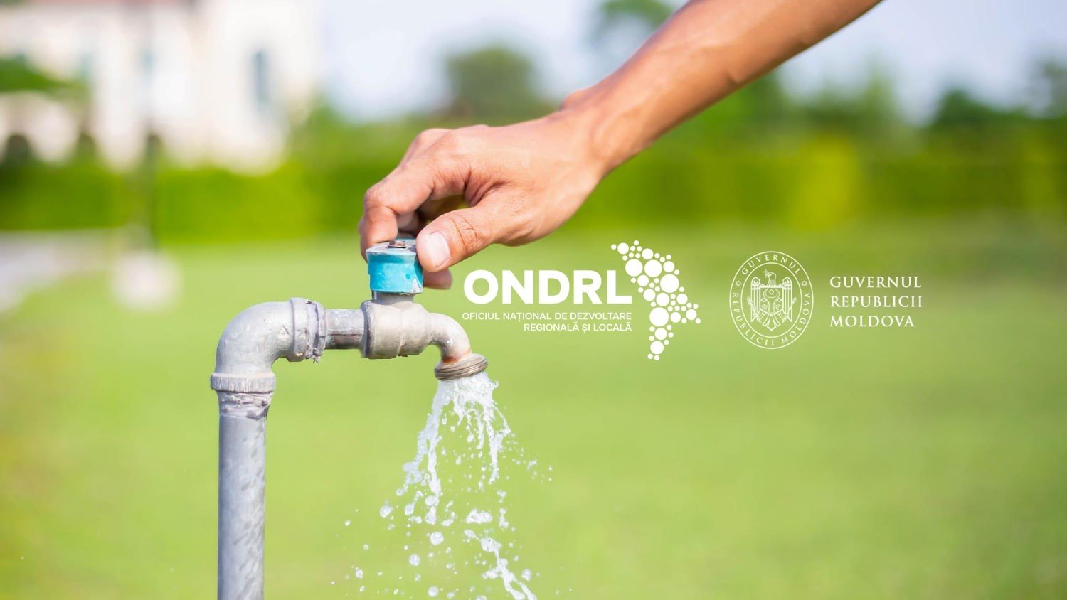 Рука открывает уличный водопроводный кран с текущей водой