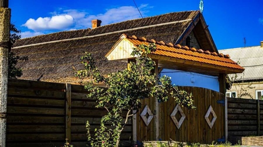 Традиционный сельский дом с соломенной крышей и деревянными воротами — типичный пример агротуристического пансионата