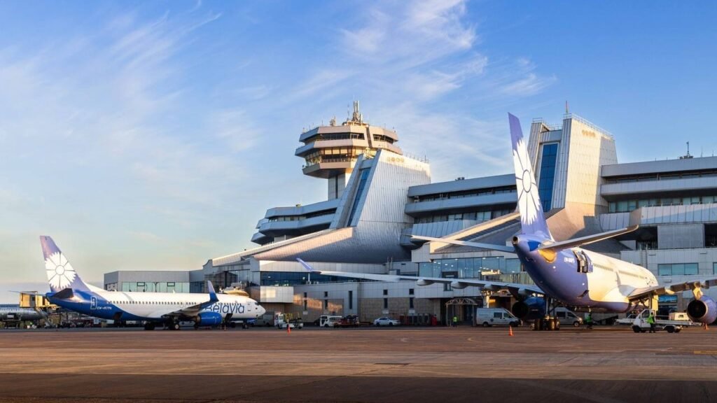 Самолёты «Белавиа» на стоянке в Национальном аэропорту Минск на фоне здания аэровокзала и диспетчерской вышки
