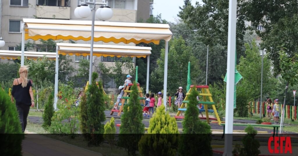 Дети на открытой площадке детского сада в Софии под жёлто-белыми навесами