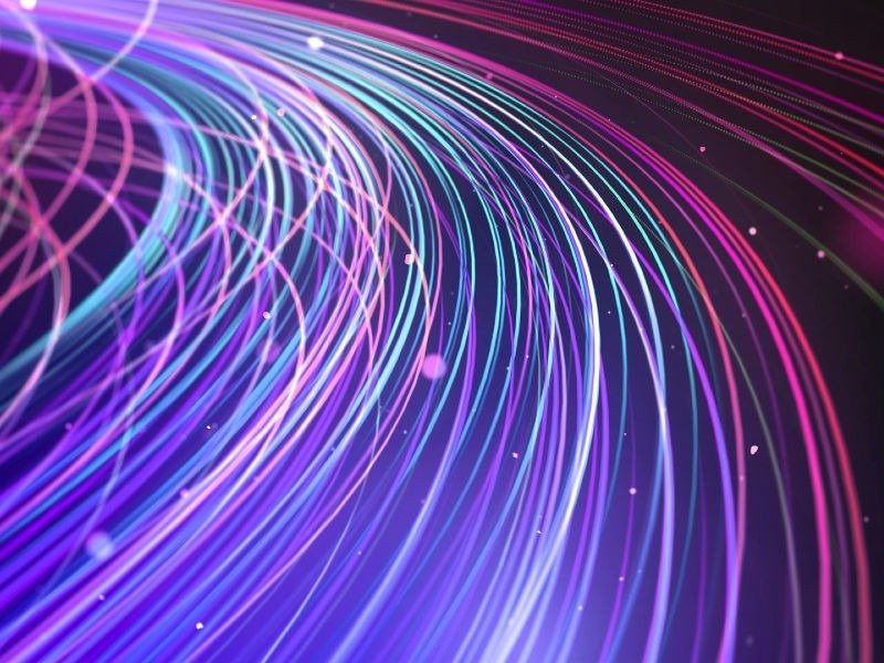 Светящиеся оптоволоконные кабели крупным планом с фиолетовыми и голубыми световыми потоками, символизирующие высокоскоростную передачу данных