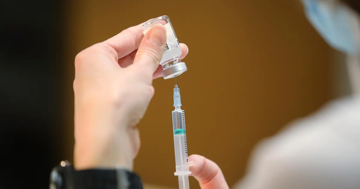 Медицинский работник набирает препарат из флакона в шприц, иллюстрируя тему профилактической медицины в контексте реформы здравоохранения