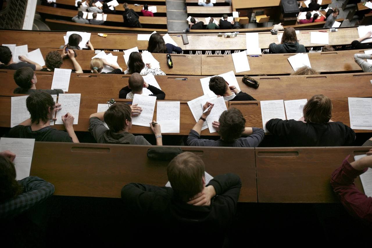 Студенты в университетской аудитории во время письменной работы