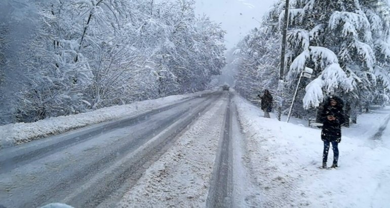 Заснеженная горная дорога в Сербии с пешеходом на обочине