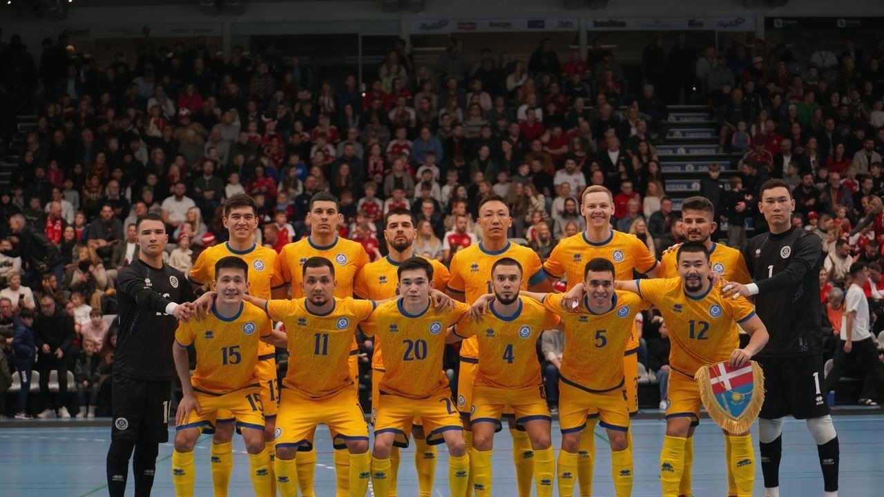 Сборная Казахстана по футзалу в жёлтой форме позирует для командного снимка перед международным матчем