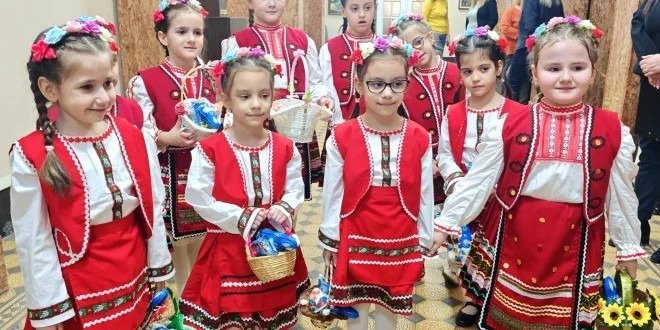 Девочки в традиционных болгарских народных костюмах с цветочными венками на празднике Цветница