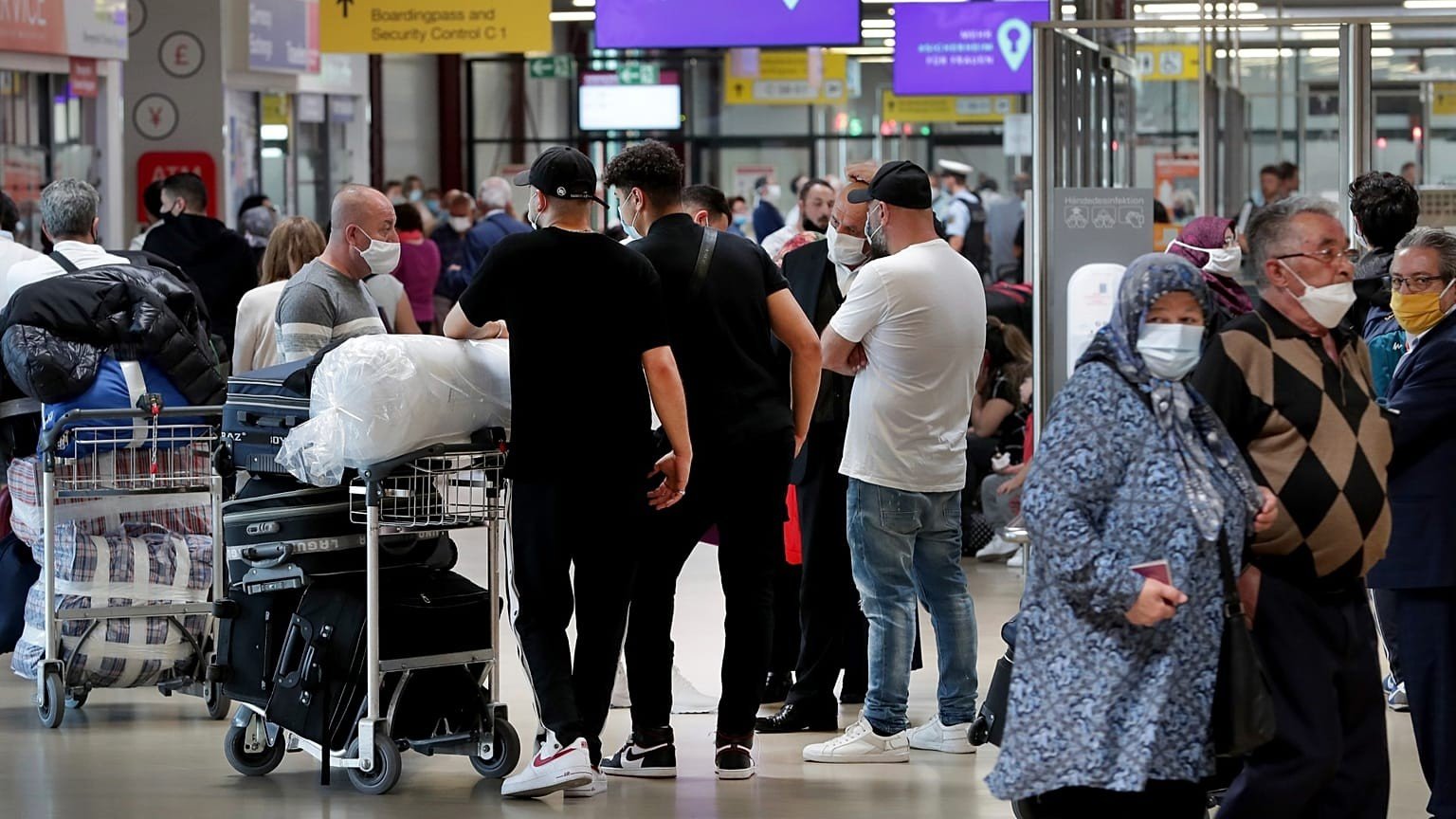 Пассажиры с багажом ожидают в зоне регистрации европейского аэропорта