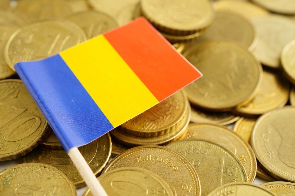 Флаг Румынии на фоне монет евро, символизирующий инвестиции в энергетику страны