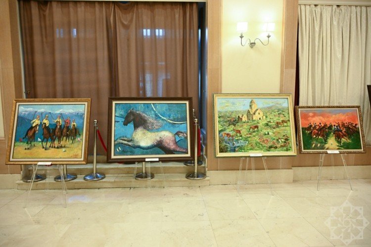 Выставка картин с изображением лошадей на мольбертах в фойе Низами Кино Центра
