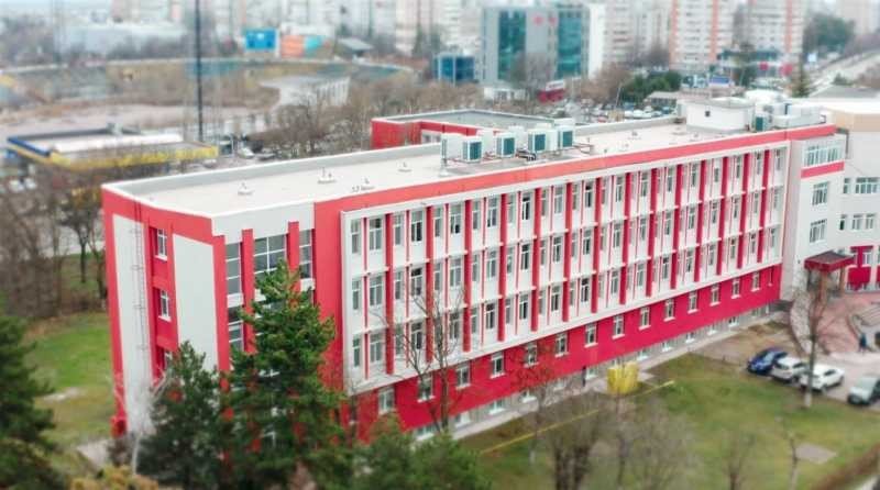 Вид сверху на корпус больницы с красно-белым фасадом