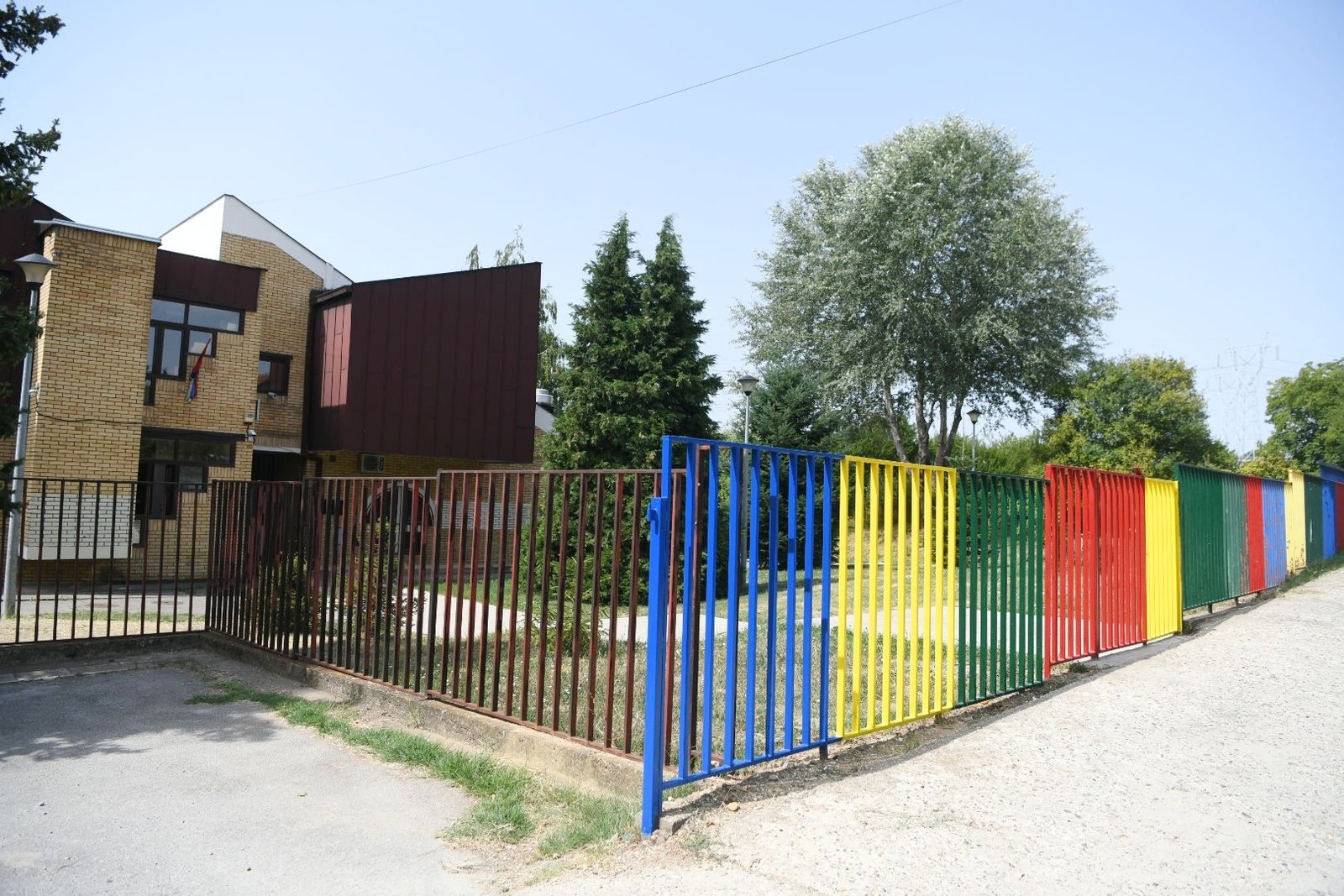 Яркий разноцветный забор перед зданием детского сада