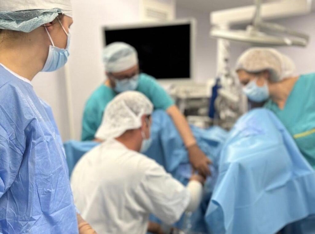 Команда хирургов в операционной во время проведения процедуры имплантации