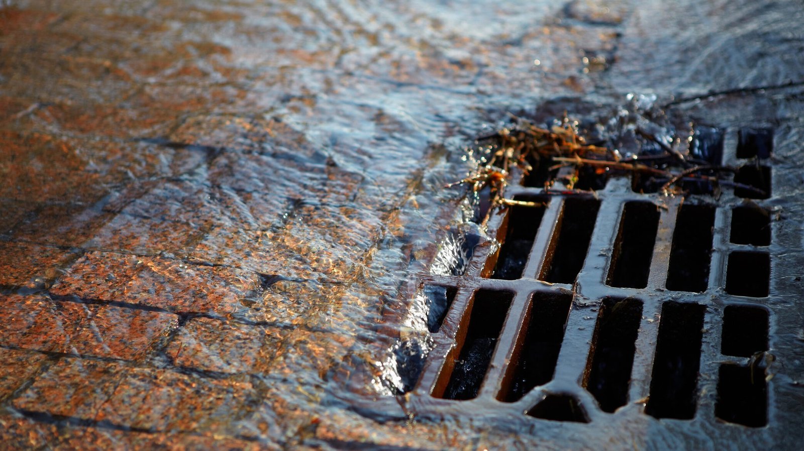 Дождевая вода стекает в городскую ливневую канализацию