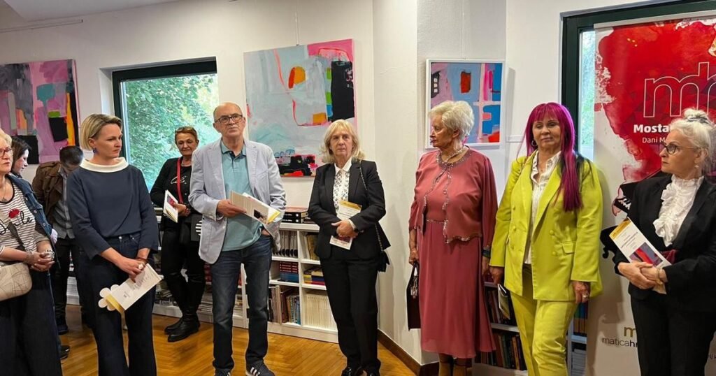 Открытие выставки «Картография восприятия» Ивоны Скочилич в мостарском Клубе книги «Иво Андрич»: гости рассматривают абстрактные работы художницы под баннером Mostarsko proljeće