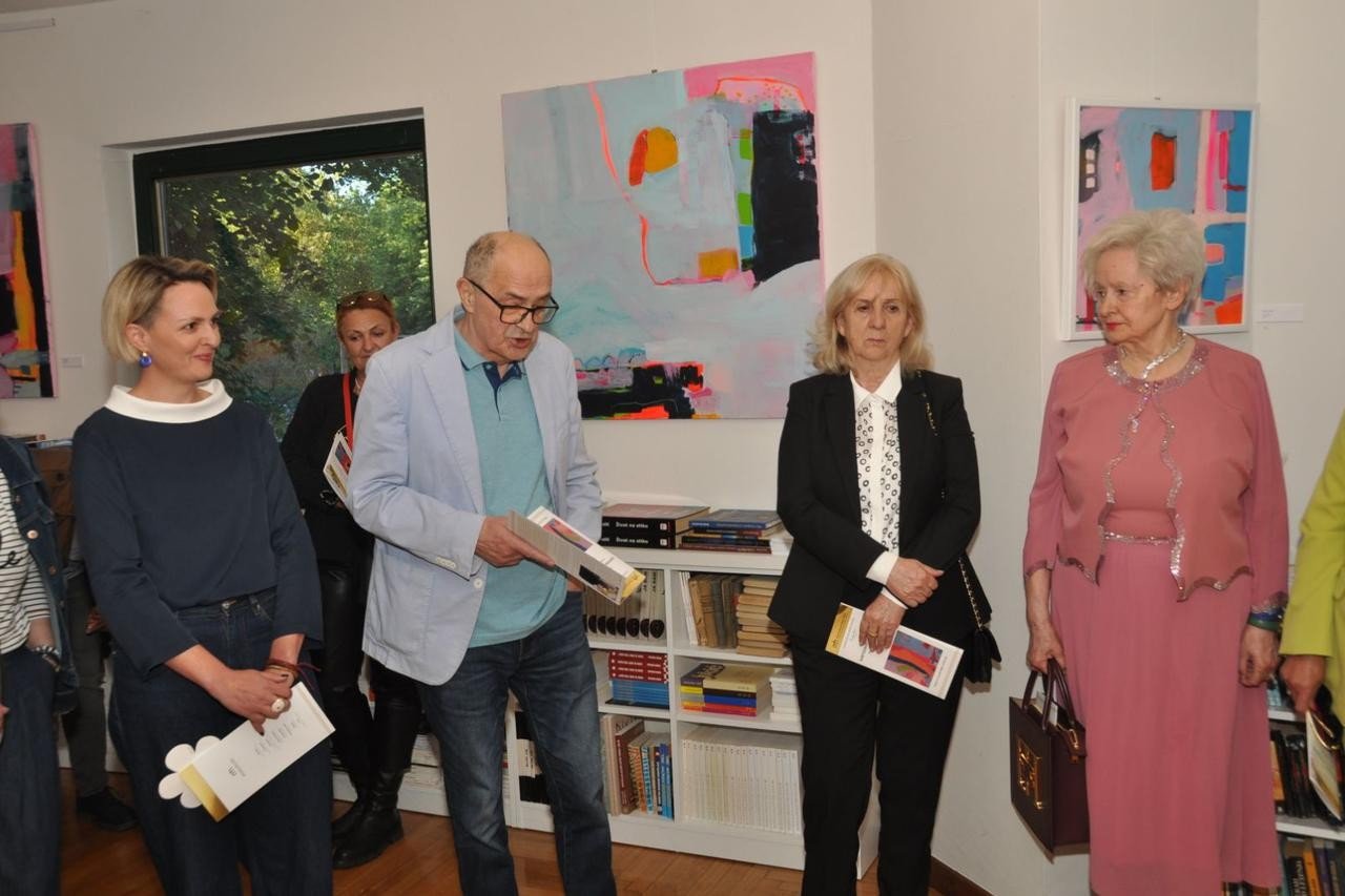 Куратор выставки и приглашённые гости во время открытия «Картографии восприятия»: на стене позади — крупная работа Ивоны Скочилич в розово-бирюзовых тонах