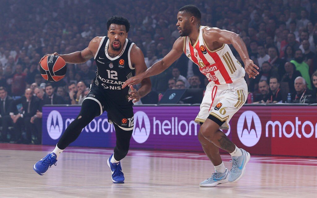 Игрок Партизана под номером 12 обходит защитника Црвены Звезды с мячом на площадке Евролиги