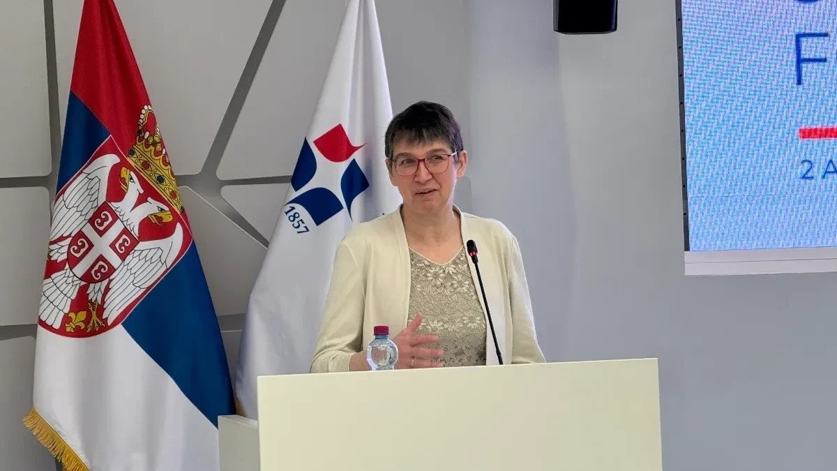 Спикер выступает на трибуне Привредной коморы Сербии на фоне государственного флага во время конференции по электромобильности