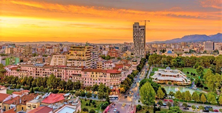 Панорама Тираны на закате: исторический центр, новые высотки и парк имени Риния — столица Албании в часы пиковой туристической нагрузки