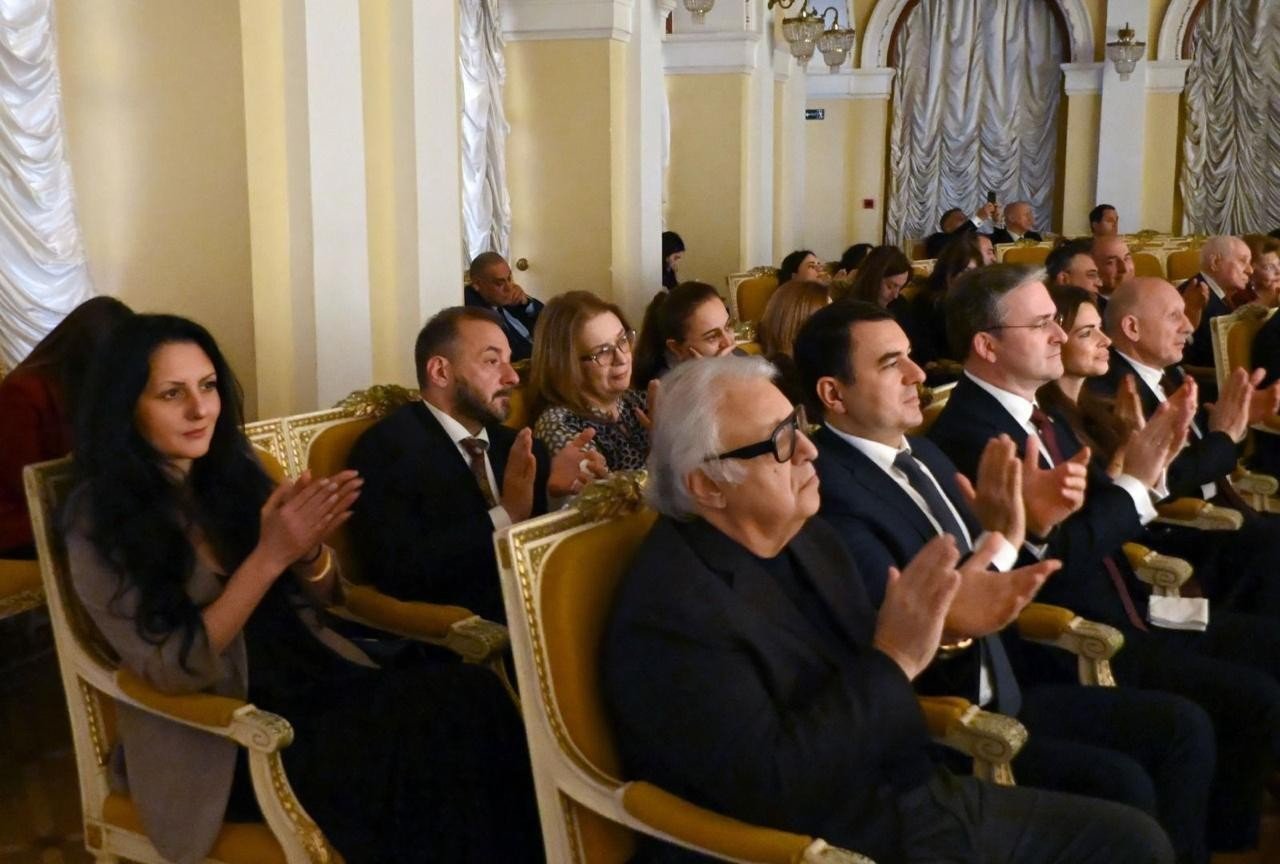 Гости концерта — официальные лица и деятели культуры — аплодируют артистам в позолоченных креслах партера филармонии