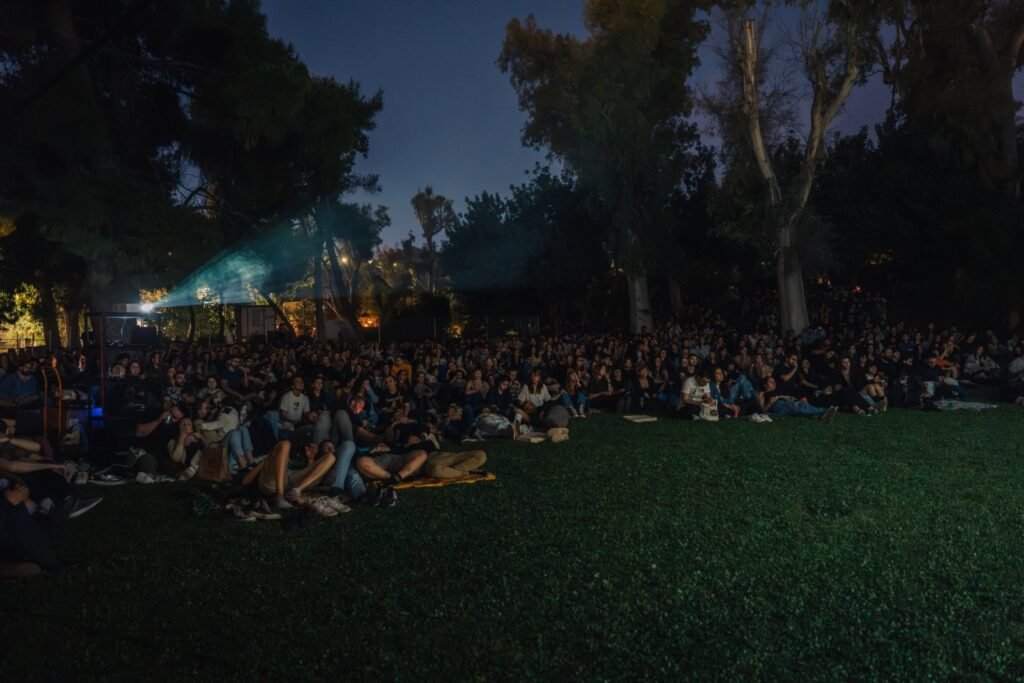 Большая аудитория на траве в Парке Элевтериас на вечернем сеансе Greek Cinema Nights Афинского фестиваля