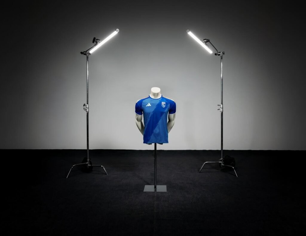 Новая синяя джерси сборной Косово от adidas установлена на манекен в фотостудии между двумя осветительными софтбоксами