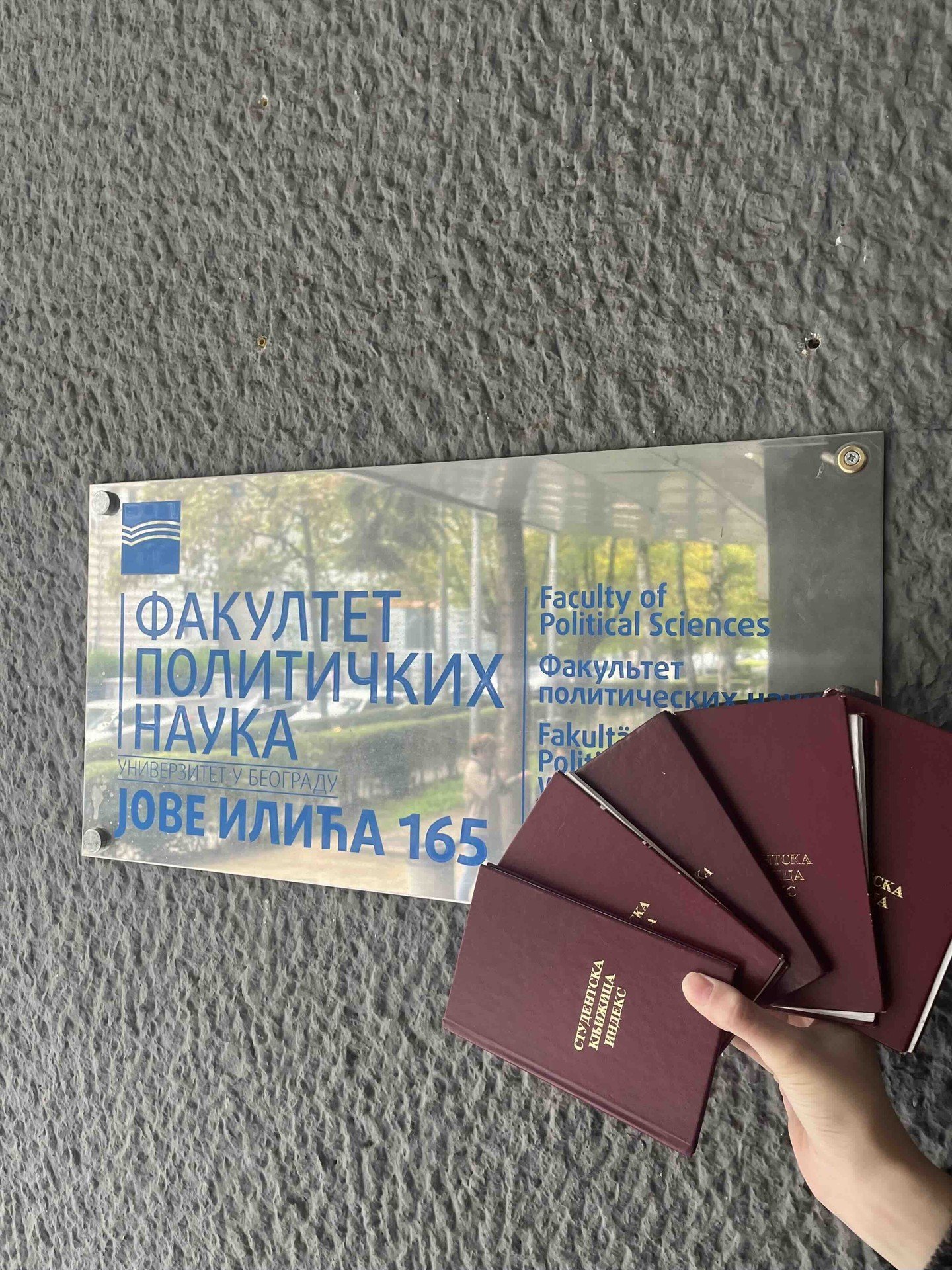 Информационная табличка у входа на Факультет политических наук Белградского университета (Jove Ilića 165) и студенческие зачётные книжки — учреждение, ставшее новым партнёром APSU