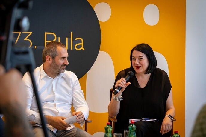 Новая директриса учреждения Pula film festival Влатка Коларович представляет программу 73-го издания фестиваля и слоган «Svemir u nama» — рядом сидит представитель организаторов