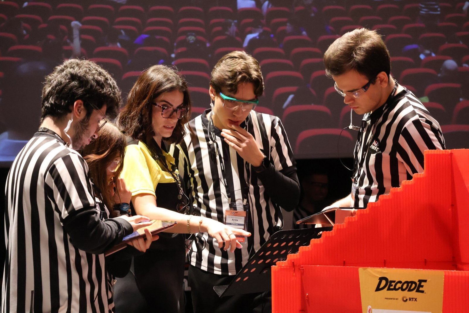 Судьи FIRST Tech Challenge у поля DECODE на площадке турнира в Стамбуле