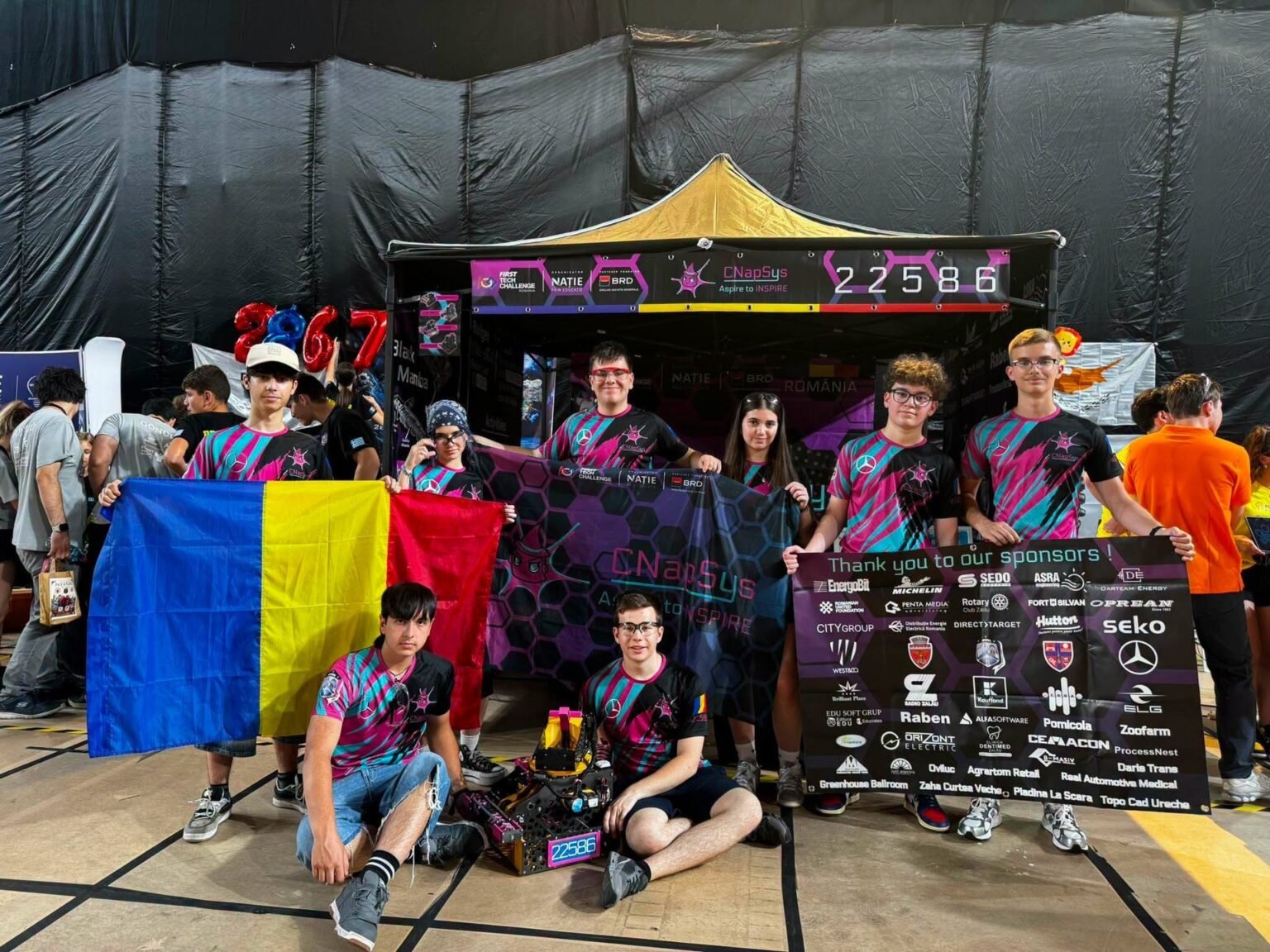 Команда CNapSys #22586 из Залэу у своего стенда на FTC İstanbul Premier Event в Турции, румынский флаг и баннер спонсоров