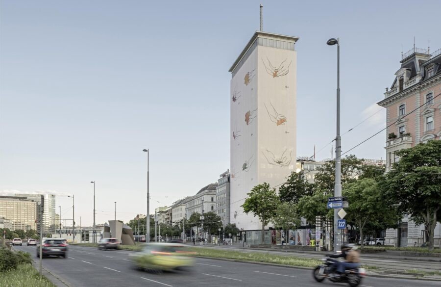 Венская башня Ringturm с инсталляцией молдавского художника Павла Брэилы: на бежевом полотне фасада — нарисованные руки, удерживающие хрупкие предметы, прохожие и трамваи движутся у подножия здания