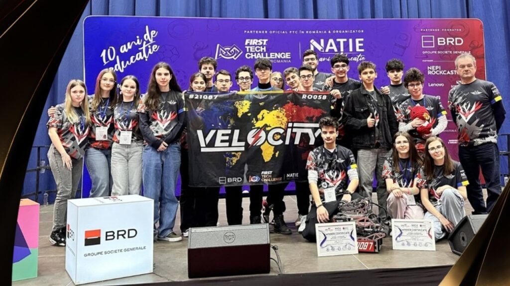 Школьники из Брэилы — чемпионы мира по робототехнике Команда Velocity из Брэилы на сцене FIRST Tech Challenge Romania держит флаг с логотипом и номерами #21087 и RO058, перед сценой робот и два диплома победителей