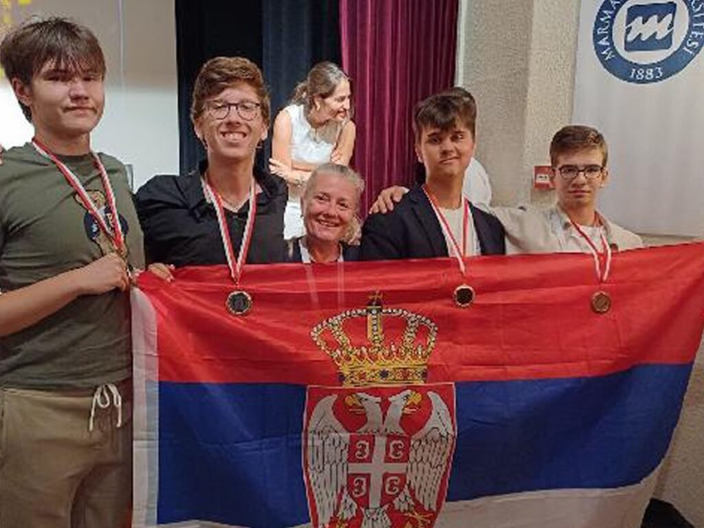 Сербские школьники привезли из Стамбула четыре медали по физике Сборная Сербии из четырёх старшеклассников с завоёванными медалями держит развёрнутый национальный флаг на фоне логотипа Университета Мармара в Стамбуле после закрытия Восьмой Балканской олимпиады по физике