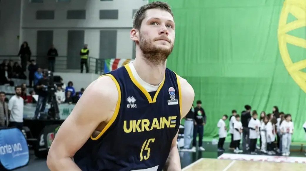 Игрок сборной Украины в тёмно-синей форме с надписью «Ukraine» и номером 15 выходит на площадку перед началом матча национальной команды