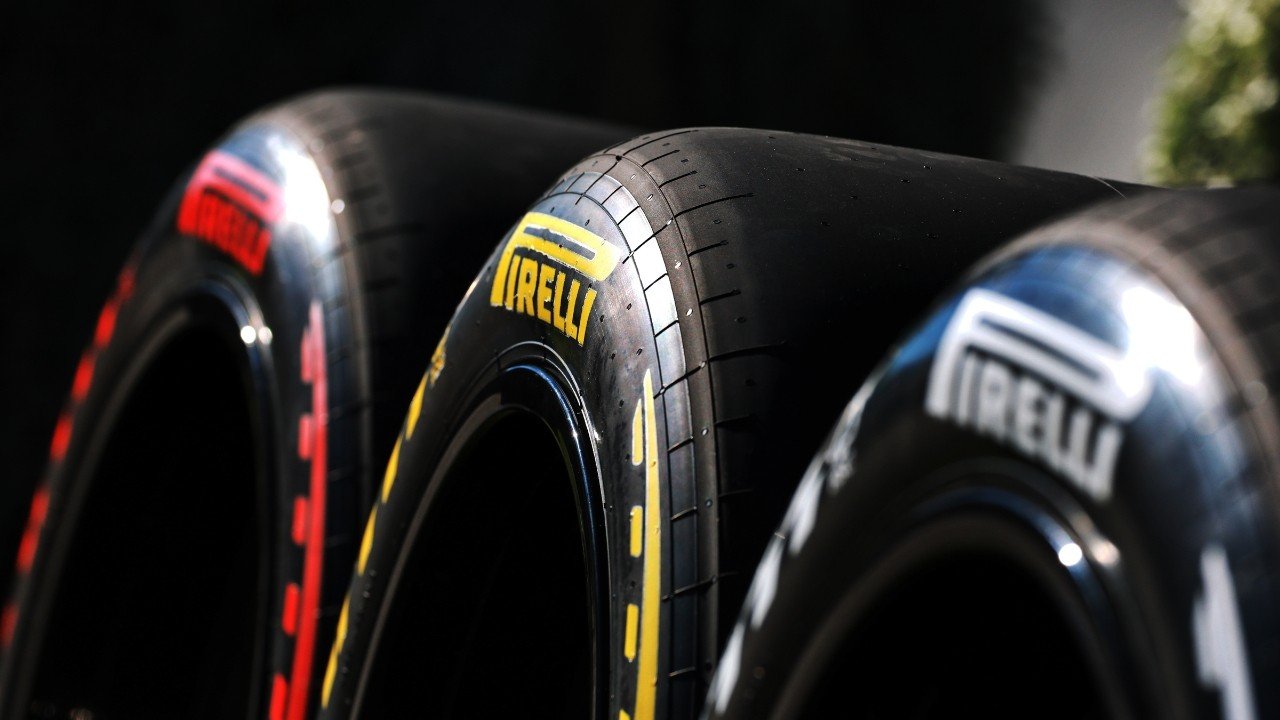 Крупный план трёх слик-шин Pirelli P Zero, выставленных в паддоке: слева виден маркер Soft (красный), в центре — Medium (жёлтый), справа — Hard (белый), фирменные логотипы Pirelli чётко читаются на боковинах