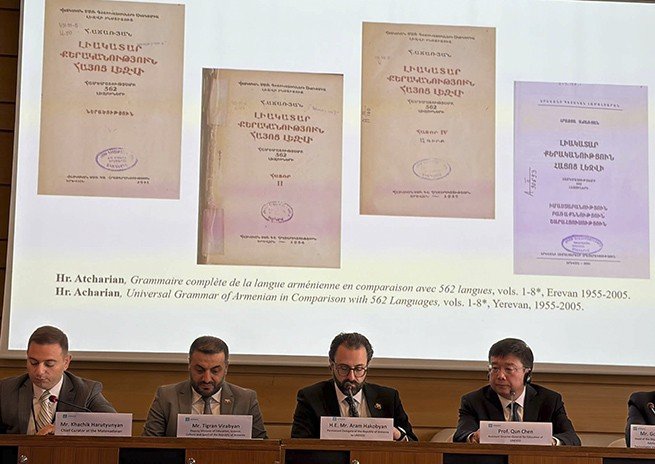 На экране — обложки восьмитомной «Полной грамматики армянского языка в сравнении с 562 языками» Грачия Ачаряна (Ереван, 1955–2005); под слайдом — спикеры конференции